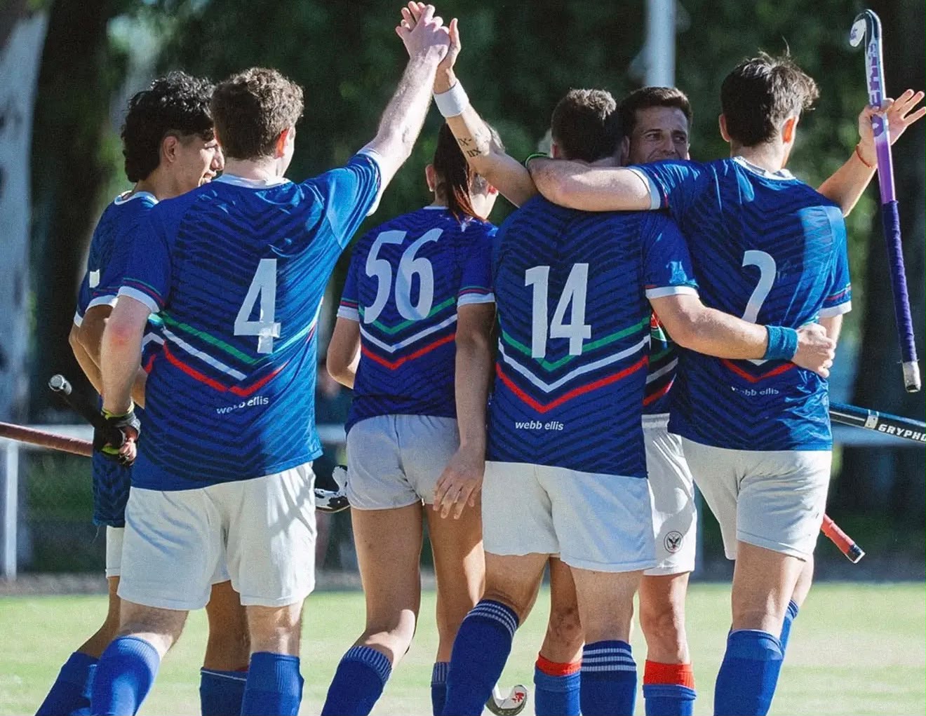 Jugadores de SITAS con camisetas azules, abrazados y festejando en la cancha.