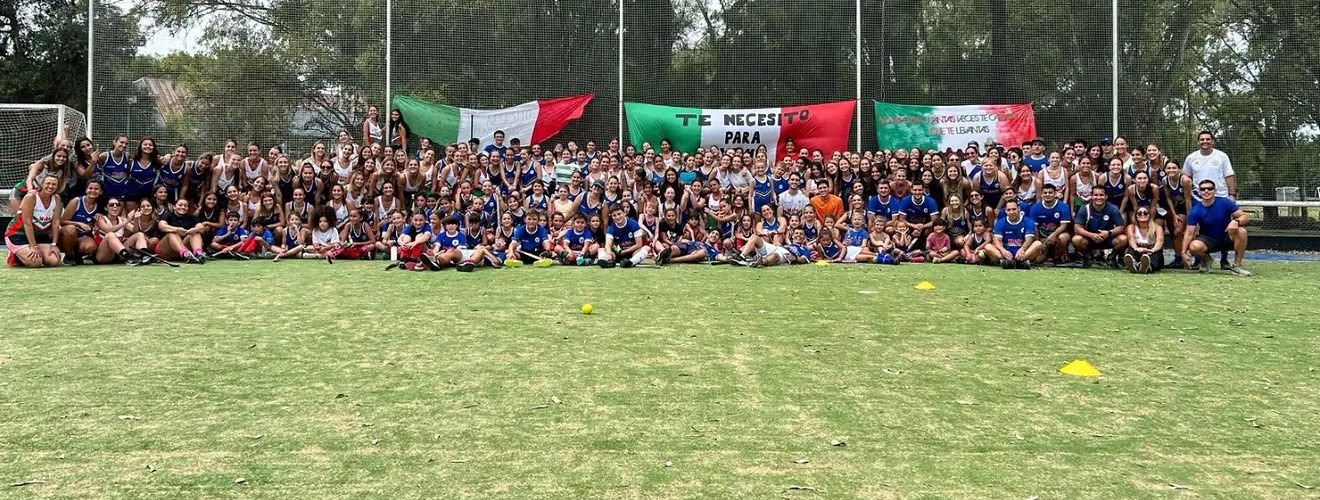 Jugadoras, jugadores y cuerpo técnico del hockey de SITAS posando juntos en la cancha.